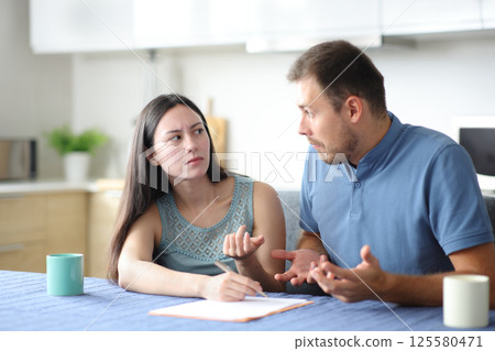 Angry asian woman asking her confused partner about document Angry asian woman asking her confused partner about document 125580471