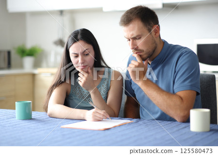 Suspicious interracial couple or roommates checking document Suspicious interracial couple or roommates checking document 125580473