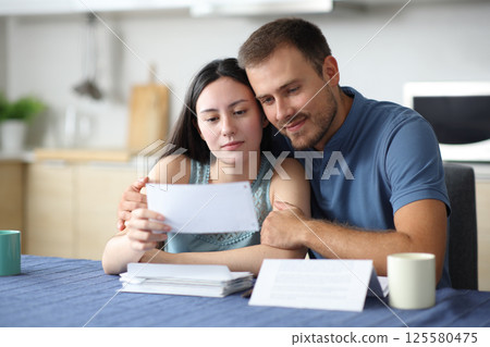 Satisfied interracial couple in love checking letter 125580475