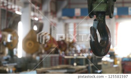 Closeup of swivel chain hook crane of electric hoist in factory workshop, pullersSwivel chain hook equipment for pullers, industry lifting machine 125581597