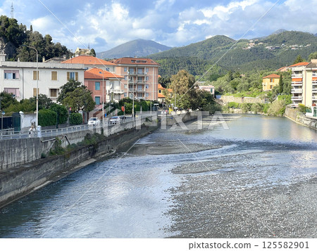 Mountain river, traditional buildings in town of Italy. Tourism and vacation, Liguria. Sunny day and nature. Background for design. 125582901