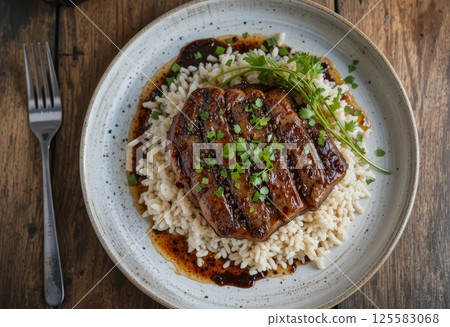Pan-roasted ribeye in teriyaki sauce, rice, top view. 125583068