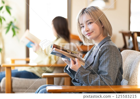 Young woman relaxing on the sofa and reading a book 125583215