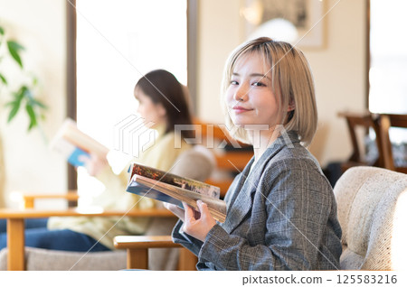 Young woman relaxing on the sofa and reading a book 125583216