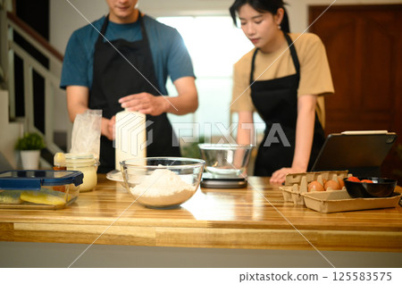 Young couple preparing pancake batter together in a cozy kitchen Young couple preparing pancake batter together in a cozy kitchen 125583575