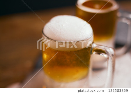 mug of beer on wooden table 125583869