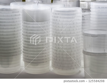 Transparent containers arranged in stacks on a table in a well-lit area Transparent containers arranged in stacks on a table in a well-lit area 125584208
