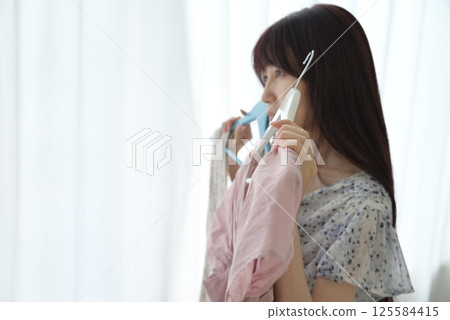 一位女士正在挑選衣服 125584415