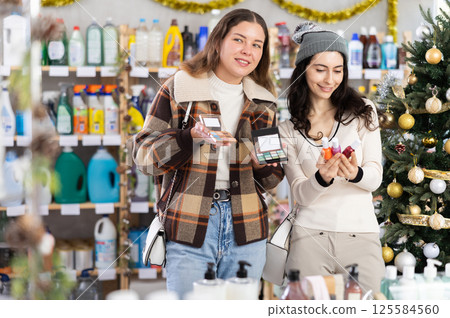 Women friends choose cosmetics and nail polish in decorated store 125584560