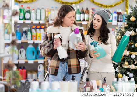 Two women choose detergents and sprays at great Christmas discounts Two women choose detergents and sprays at great Christmas discounts 125584580