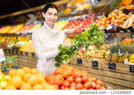In vegetable store, young woman customer buy celery 125584668