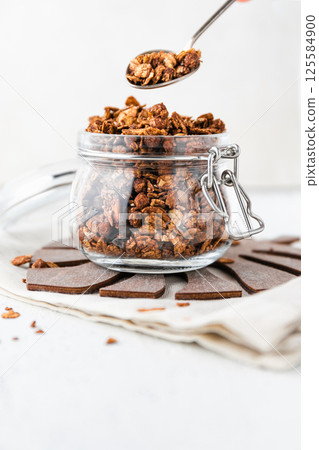 Granola or baked oat flakes with chocolate and nuts. Healthy and simple breakfast. Granola or baked oat flakes with chocolate and nuts. Healthy and simple breakfast. 125584900