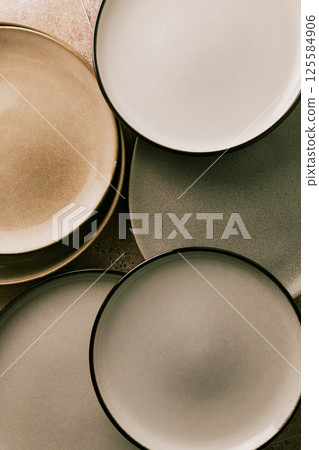 Top view of modern various ceramic plates on a kitchen table, abstract composition, vintage colors. Top view of modern various ceramic plates on a kitchen table, abstract composition, vintage colors. 125584906