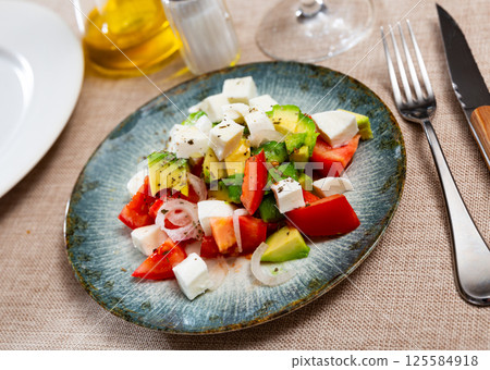 Salad with avocado, tomatoes, onions and cheese 125584918