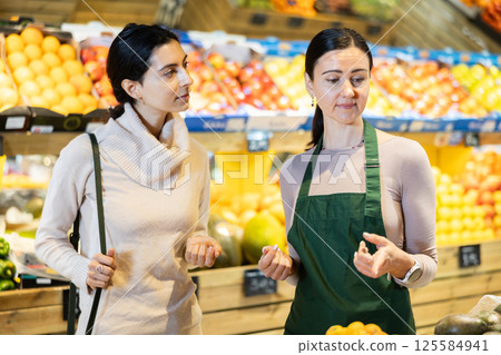 saleswoman advises a store client 125584941