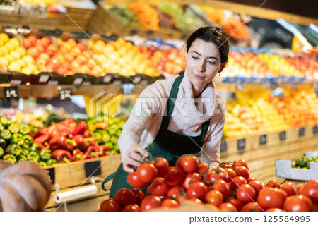 seller stands behind the tomato counter seller stands behind the tomato counter 125584995