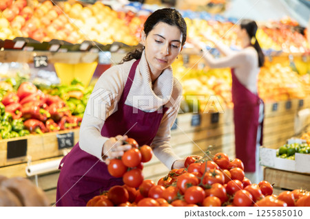 seller stands behind the tomato counter seller stands behind the tomato counter 125585010