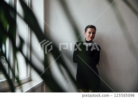 Beautiful slim woman with short haircut in black fashion dress 125585096