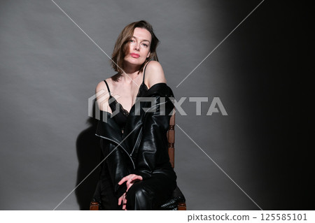 Beautiful woman in leather suit and black lingerie 125585101