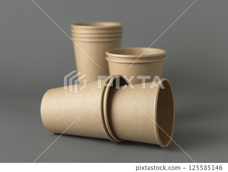 Disposable beige kraft paper cups on a gray closeup, mockup. No plastic and sustainable lifestyle Disposable beige kraft paper cups on a gray closeup, mockup. No plastic and sustainable lifestyle 125585146