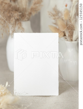 Blank card near dry beige pampas grass on linen closeup, mockup. Bohemian wedding stationery 125585150