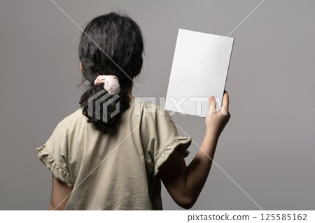 Backside of a little girl holding a novel book inside hand mock-up series Backside of a little girl holding a novel book inside hand mock-up series 125585162