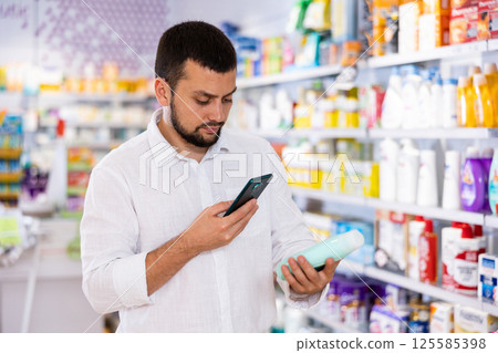 Man photographing skin or hair care product in drugstore Man photographing skin or hair care product in drugstore 125585398