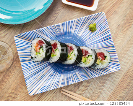 Set of japanese rolls futomaki with soy and chili sauces close up 125585434