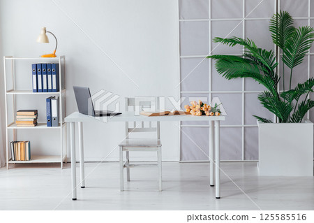 A desk with a laptop and documents in the interior of a office A desk with a laptop and documents in the interior of a office 125585516