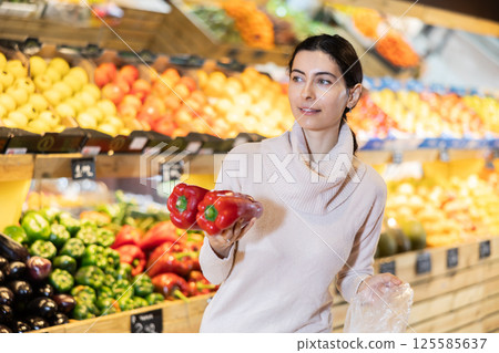 In vegetable store, young woman customer buy bell pepper In vegetable store, young woman customer buy bell pepper 125585637
