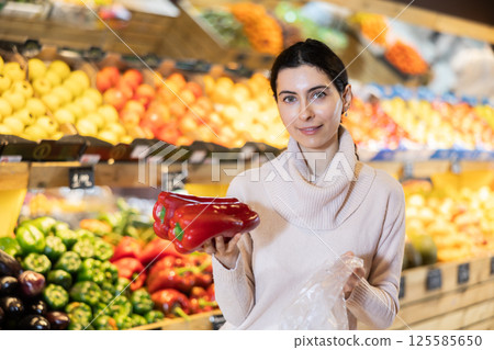 In vegetable store, young woman customer buy bell pepper In vegetable store, young woman customer buy bell pepper 125585650