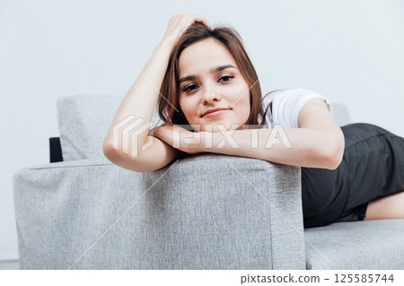 woman lying on gray office sofa in white room woman lying on gray office sofa in white room 125585744