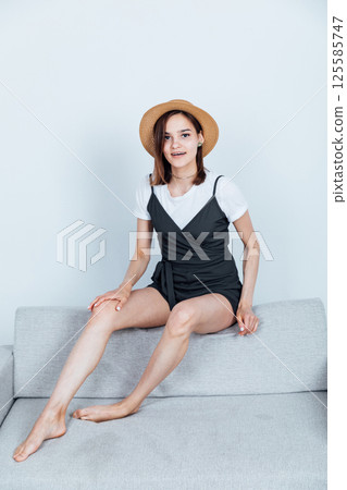 fashionable woman sitting on gray office sofa fashionable woman sitting on gray office sofa 125585747