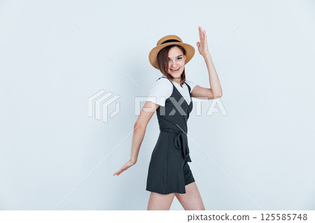 Beautiful fashion woman in sundress and hat smiling on white background Beautiful fashion woman in sundress and hat smiling on white background 125585748