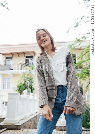 woman in a gray jacket walking through the streets of the city 125585752