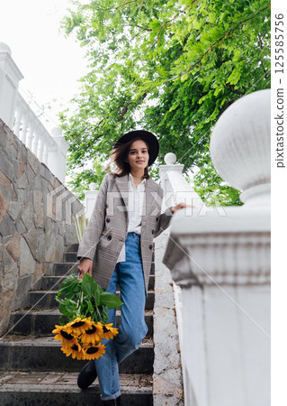 woman with yellow sunflower flowers walking woman with yellow sunflower flowers walking 125585756
