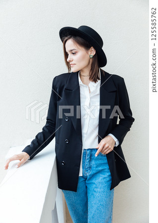 Portrait of a fashionable woman in a black jacket and hat 125585762