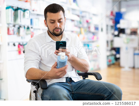 Disabled man with phone at drug store 125586017
