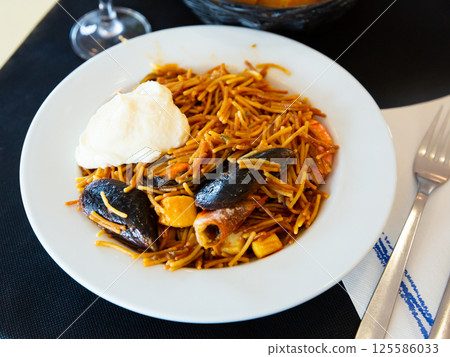 Fideua, noodle paella on white plate 125586033