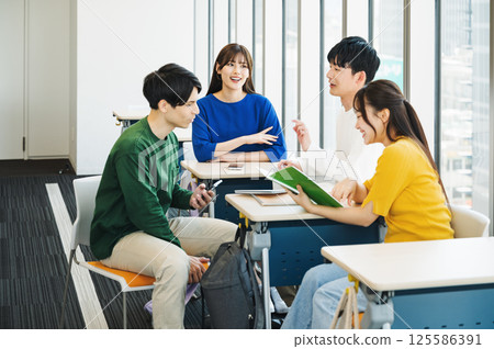 Male and female students chatting during break in a school classroom Male and female students chatting during break in a school classroom 125586391