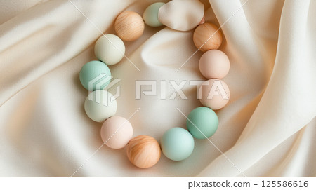 Handmade eco bracelet with pastel wooden beads on soft fabric background. Concept of natural fashion, sustainable accessories, minimalist style, eco jewelry, bohemian elegance, organic materials Handmade eco bracelet with pastel wooden beads on soft fabric background. Concept of natural fashion, sustainable accessories, minimalist style, eco jewelry, bohemian elegance, organic materials 125586616