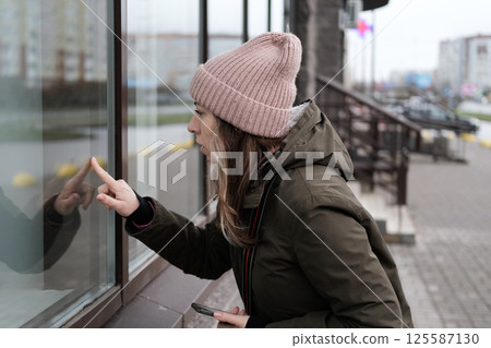 Portrait of mature woman in wool hat standing on the urban street, drinking takeaway coffee from paper cup. Middle-aged 40s female walking around the city at cold autumn day. Living in modern district Portrait of mature woman in wool hat standing on the urban street, drinking takeaway coffee from paper cup. Middle-aged 40s female walking around the city at cold autumn day. Living in modern district 125587130