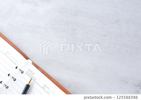 Image of a ring-type system organizer open while doing desk work Image of a ring-type system organizer open while doing desk work 125588398