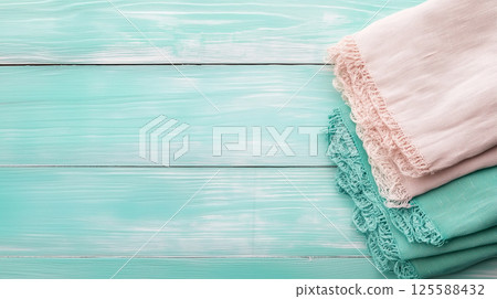 Neatly folded linen towels on turquoise wooden surface. Clean visual for rustic home decor, eco lifestyle, and natural textile themes Neatly folded linen towels on turquoise wooden surface. Clean visual for rustic home decor, eco lifestyle, and natural textile themes 125588432