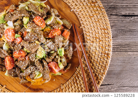Delicious stir fried beef mixed with fresh vegetables garnished with sesame seeds, perfect for sharing at mealtime with Asian cuisine tasty Delicious stir fried beef mixed with fresh vegetables garnished with sesame seeds, perfect for sharing at mealtime with Asian cuisine tasty 125589228