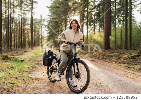 Finding balance one pedal at a time, a traveler is cycling through forest trails at sunset for the ultimate wellness recharge Finding balance one pedal at a time, a traveler is cycling through forest trails at sunset for the ultimate wellness recharge 125589952