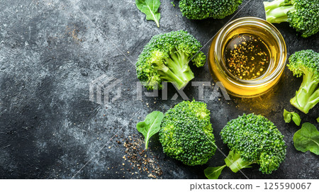 Fresh broccoli with rich olive oil and spices on dark textured surface. concept of healthy eating, mediterranean cuisine, cooking ingredients, Copy space Fresh broccoli with rich olive oil and spices on dark textured surface. concept of healthy eating, mediterranean cuisine, cooking ingredients, Copy space 125590067