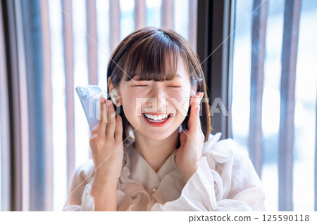 聽到在智能手機的音樂的一個少婦 125590118