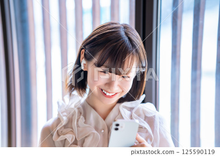 A young woman listening to music on a smartphone A young woman listening to music on a smartphone 125590119