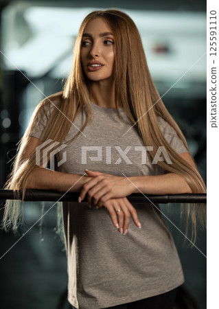 fitness enthusiast stands confidently gym dressed in casual gray t shirt while preparing for intense workout session focused on strength training and wellness. fitness enthusiast stands confidently gym dressed in casual gray t shirt while preparing for intense workout session focused on strength training and wellness. 125591110